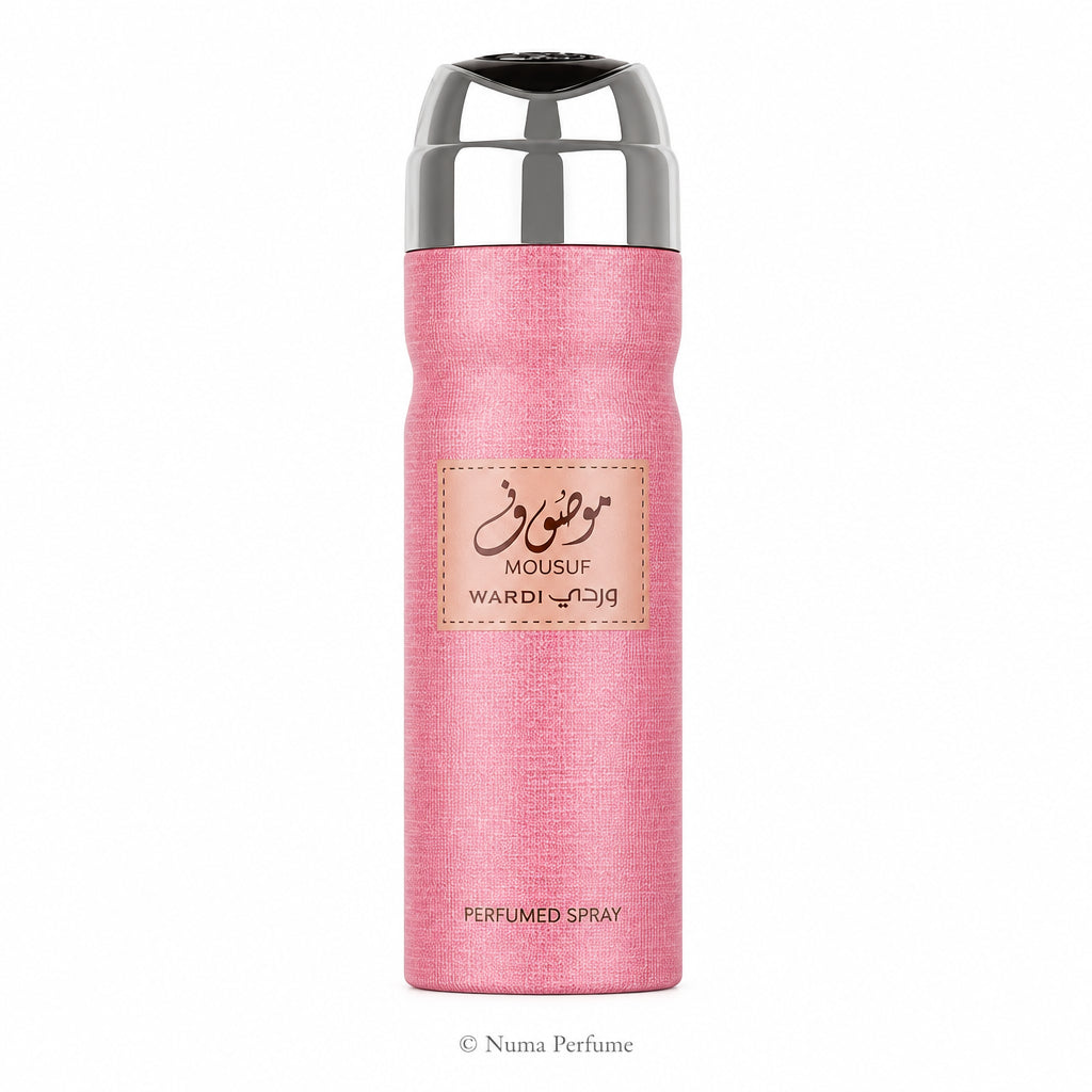 A pink textured cylindrical perfume spray bottle with a shiny silver metallic cap, featuring a central beige label with Arabic calligraphy and the brand name Wardi Mousuf.