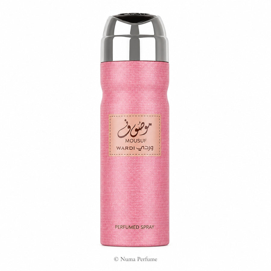 A pink textured cylindrical perfume spray bottle with a shiny silver metallic cap, featuring a central beige label with Arabic calligraphy and the brand name Wardi Mousuf.